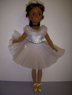 the doll is wearing a white dress and gold shoes