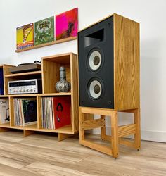 two bookshelves with speakers on them in front of a wall mounted stereo system