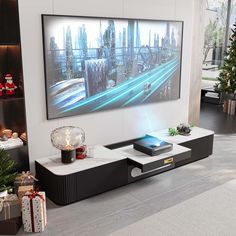 a modern living room with a large television on the wall and christmas presents in front of it