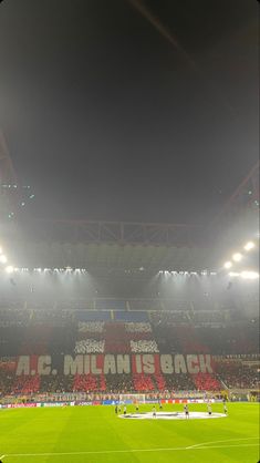 an empty soccer stadium with fans on the sidelines and lights in the dark sky