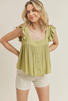 Product Details: Color: Mellow Green Sleeveless top Ruffle strap detail Button front Lightweight material Relaxed / flowy fit Hand wash cold / line dry Fabric contents: 100% Rayon Trendy Flowy Sleeveless Blouse, Casual Summer Blouse With Ruffled Straps, Casual Spring Blouse With Ruffled Straps, Flowy Sleeveless Rayon Top, Casual Cami Blouse With Ruffles, Spring Cami Top With Buttons, Spring Rayon Tops With Buttons, Flowy Summer Tops With Ruffled Straps, Sleeveless Rayon Top With Ruffles