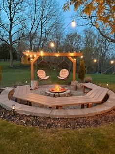 a fire pit surrounded by wooden benches and lights