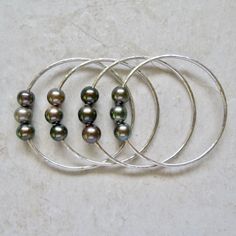 "Silver Triple Tahitian Pearl Bangle~ Beautiful sterling silver bangle with three colorful Tahitian pearls, looks great with one or more, mix and match with our other bangles. Listing is for one sterling silver thick 12 gauge bangle with three genuine Tahitian pearls. Tahitian pearls approx. 9-10mm. Please view the last picture on this listing that shows how to measure for your correct size as there will be a charge for size exchange! For correct size measure the circumference of your hand with Pearl Bangles Gold, Surfer Girl Gifts, Tahitian Pearl Ring, Hammered Bracelet, Pearls Wedding, Tahitian Pearl Necklace, Gold Heart Ring, Black Pearl Necklace, Pearl Bangle