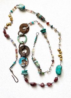 Long, luxurious array of wire-wrapped gemstones juxtaposed with recycled rusty washers. One of a kind, but similar necklaces may be created upon request. Gemstones include: turquoise, chrysocola, raw rubies, freshwater pearls, amber, moonstones, tanzanite, quartz, aquamarine, emerald, rose quartz, emerald, citrine, and turquoise. Faceted gems range from 6mm to 3mm. Turquoise chunks are about 1/2 to 3/4 inch. Chrysocola discs are approximately 3/8 inch. I have wire-wrapped each stone with fine si Bohemian Jewelry With Natural Stones In Freeform, Earthy Wire Wrapped Jewelry For Festivals, Artisan Soldered Round Beads Jewelry, Bohemian Hand Forged Necklaces For Festivals, Bohemian Freeform Wire Wrapped Jewelry, Artisan Wire Wrapped Lariat Jewelry, Bohemian Rust Necklace With Natural Stones, Artisan Jewelry With Stones For Festivals, Artisan Festival Jewelry With Stones