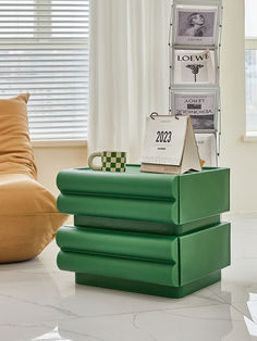 a stack of green boxes sitting on top of a white floor next to a window