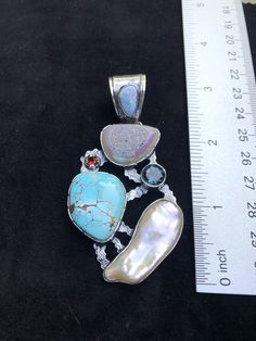 "Artisan Turquoise gemstone Pendant Hand-made Sterling Silver 925. Stones used: Rainbow Druzy, Turquoise, Australian Opal, Pearl, London Blue Topaz, Garnet Height - 3\" (with bail), Width - 1 5/8\" Height -75mm (with bail), Width - 40mm Unique Handcrafted One-of a-kind Design Each Piece of Jewelry in my Collection is Absolutely One of a Kind! When you start wearing a piece of my jewelry you will fall in love with it more and more each day and feel that good Energy and Love that I pass into it wh Blue Turquoise Necklace With Stones, Unique Blue Turquoise Necklace With Stones, Collectible Blue Turquoise Gemstone Necklace, Turquoise Multi-stone Round Gemstones, Turquoise Multi-stone Gemstones, Elegant Multi-stone Turquoise Gemstones, Artisan Turquoise Stone Necklace, Artisan Round Natural Stones Gemstones, Artisan Round Natural Gemstones