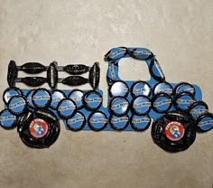 a truck made out of bottle caps sitting on top of a floor next to a wall