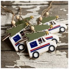 three decorated christmas tree shaped cookies on top of a wooden table next to string lights