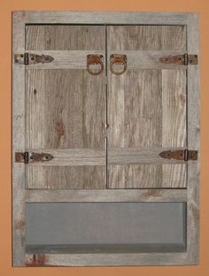 an old wooden cabinet with two doors and some knobs on the front, against a tan wall