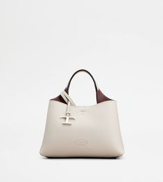 Bag in soft exposed grain leather, with Tod's logo stamped on the front, flat handle and removable shoulder strap. The interior comes with 2 compartments separated by a central zipped pocket. An elegant creation enhanced by distinctive iconic detailing, such as the metal T Timeless pendant and T-stitching. Off White Bag, Tods Bag, Grey Bag, Boston Bag, Timeless Accessories, Logo Stamp, Leather Items, Leather Mini, White Bag