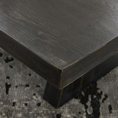 a wooden table sitting on top of a carpeted floor next to a black rug