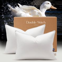 two white pillows sitting next to each other in front of a box with water splashing on it