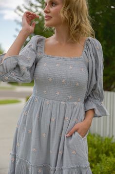 This stunning puff sleeve midi dress features a smocked bodice, embroidered flowers, tiered skirt and pockets for an ultra-feminine look. The puff sleeve midi dress is perfect for any special occasion. This dress pairs comfort and style for a standout look that will earn you compliments. steel blue embroidered florals smocked top square neckline lined pockets midi maxi length true to size Self: 100% cotton / Lining: 100% polyester hand wash cold model is wearing a small. Height is 5'5" Spring Puff Sleeve Dress With Smocked Balloon Cuffs, Spring Dress With Smocked Cuffs And Square Neck, Spring Smocked Dress With Square Neck And Gathered Sleeves, Spring Smocked Dress With Gathered Sleeves For Brunch, Spring Brunch Smocked Dress With Gathered Sleeves, Spring Smocked Dress With Gathered Sleeves For Day Out, Midi-length Puff Sleeve Dress For Garden Party, Summer Dress With Balloon Sleeves And Smocked Cuffs, Midi Length Puff Sleeve Dress For Garden Party