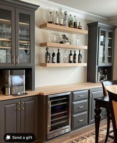 a kitchen with gray cabinets and shelves filled with bottles, wine glasses, and an oven