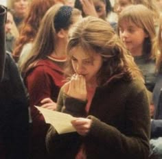 a group of young people standing next to each other in front of a table with papers