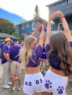 two girls in purple and white cheer for the team