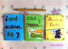 three children's notebooks with spanish words and pictures on them, next to a pencil