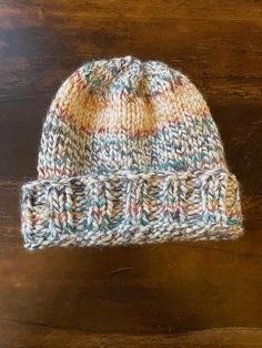 a knitted hat sitting on top of a wooden table