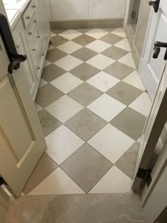 a white and gray checkered floor in a bathroom with two doors open to reveal another room