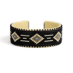 a black and gold beaded bracelet on a white background, with beads in the middle