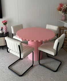 a pink table with four chairs around it