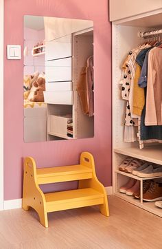 a yellow bench sitting in front of a mirror on top of a wall next to a shelf