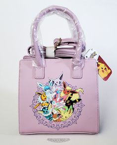 a pink handbag with pokemon pictures on the front and side handles, attached to a white background