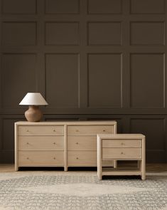 a lamp and two dressers in front of a brown wall