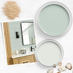 two white bowls with seashells on them next to a mirror and other items