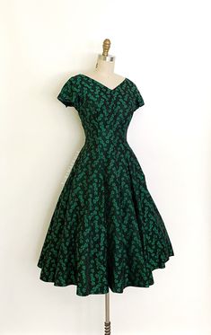 vintage dress  Era: 1950's Label: none Material: feels like a satin rayon brocade Closure: side metal zipper Colour: black, green  Details: timeless fit and flare mid century evening dress with a floral and climbing leaf pattern, fitted bodice with a v neckline, short sleeves, nipped waist, full skirt Bust: 36" Waist: 28/29"  Hip: free Length: 44" Condition: There are seam stress to the waist darts. Some small hand repairs to the corners of the underarm gussets. A small hole at the top left shoulder.  Priced according.  shop policy  * All items are a final sale. No returns, exchanges and, order cancellations are not accepted.  * Ruby Mae Rose is not responsible for lost or stolen parcel(s) and any duty, import, VAT charges that are determined by the receiving country. Ruby Mae Rose will no Brocade Evening Dress, Mid Century Party, 1950’s Dress, Ruby Mae, 1950's Dress, Green Details, Vintage 1950s Dresses, Rose Vintage, 1950s Dress