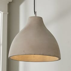 a light fixture hanging from a ceiling in a room with white walls and wood flooring