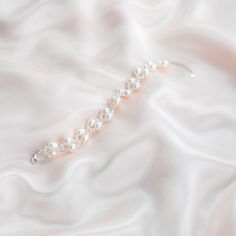 The Handmade Twist Oval Pearls Bracelet is a unique and stunning piece of jewelry that matches well with any bridal dress or other daily outfit. Made by skilled artisans, this bracelet features a twist design that adds a touch of elegance to the smooth and lustrous oval-shaped pearls. The pearls are hand-selected for their quality and color, ensuring that each bracelet is one-of-a-kind. Pearl Type: Freshwater Pearls Pearl Quality: [Shape]: Oval Shape [Pearl Size]: 6-7mm [Blemish]: Minor [Luster] Feminine Adjustable Beaded Bracelets For Wedding, Elegant Bangle Jewelry For Bridesmaid Gift, Elegant Bangle For Bridesmaid Gift, Elegant Handmade Bracelets For Bridesmaids, Elegant Handmade Bracelets As Bridesmaid Gift, White Feminine Bracelets For Wedding, Elegant Sterling Silver Pearl Bangle Bracelet, White Sterling Silver Crystal Bracelet For Wedding, Elegant Crystal Bangle Bracelet