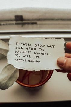 someone is holding up a piece of paper that says flowers grow back even after the harshest winter you will too