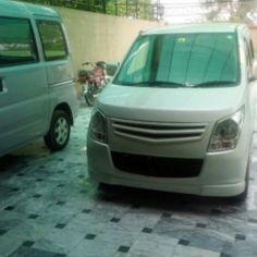 a white van parked next to a silver van on top of a checkered floor