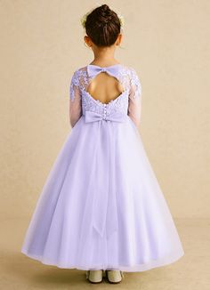 Precious is the perfect dress for your little princess. She features a beautiful lace bodice with a scoop neckline, full length illusion lace sleeves, a keyhole back, a button back with a bow, and a ruched tulle A-line skirt. Flowergirls Dress Purple, First Communion Dresses With Floral Applique Tulle, Lilac Flower Girl Dresses, Lilac Dress Kids Casual, First Communion Dress With Lace Bodice, Tulle, Flower Girl Dresses Tulle, Lilac Flowers, Lace Bodice, Lace Sleeves