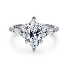 an engagement ring with a pear shaped diamond center and three side stones on the band