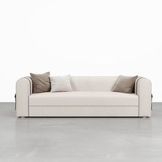 a white couch sitting on top of a cement floor