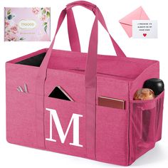 a pink tote bag with the letter m on it's side and an envelope in the back