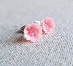 I love Japanese art and design. Cherry blossoms are a cornerstone of Japanese culture and one of my favorite floral designs. This is my own interpretation of the bloom, and I hope to have other floral varieties to add soon!I handcraft the little blossoms out of a combination of Premo and Fimo clay, to get the most durable polymer clay blossom possible. The color is a custom mix to be a very light translucent pink, with a darker pink center. Even though they look delicate, the blooms are incredib Unique 3d Flowers Jewelry Gift, Unique 3d Flower Jewelry, Unique 3d Flower Shaped Jewelry, Dainty Flower Shaped Jewelry With 3d Flowers, Dainty 3d Flower Jewelry, Dainty Jewelry With 3d Flower Details, Dainty Jewelry With 3d Flowers For Gift, Pink Flower Earrings Gift For Her, Unique Pink Flower Earrings As Gift