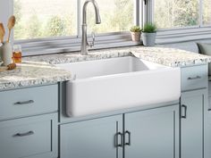 a white kitchen sink sitting under a window