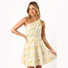 Embrace the sunny side of fashion with the Cintrico One Shoulder Mini Dress in a zesty Lemon print. With its playful one-shoulder style, asymmetric neckline, and whimsical knot detail, you'll be the epitome of summer chic. Spring Vacation Dress With Asymmetrical Neckline, Summer Dress With Asymmetrical Neckline For Day Out, Summer Brunch Dress With Asymmetrical Neckline, Spring Beach One Shoulder Fitted Dress, Summer Dress With Fruit Print For Day Out, Summer Fruit Print Dress For Day Out, One Shoulder Sundress For Day Out, Fitted One Shoulder Dress For Beach In Spring, Fruit Print Dress For Day Out