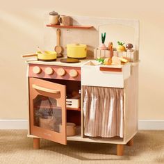 a wooden play kitchen with an oven and sink in the center, on carpeted flooring