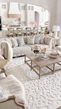 a living room filled with lots of furniture and flowers on top of a coffee table