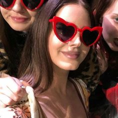 three women wearing heart shaped sunglasses taking a selfie