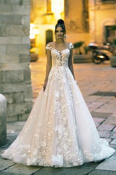 a woman in a wedding dress standing on the street