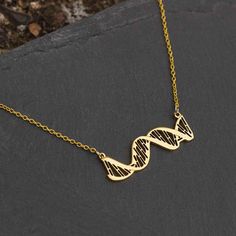 If you work with, study, or have genetic material, then this DNA necklace is for you. The highly detailed DNA pendant is strung in-line with the chain shows the major and minor grooves, as well as a representation of base pairing. It also has tiny engraved details to accurately represent the right-handed direction of the double helix twist. The pendant is made from polished steel and comes in silver, gold, and rose gold colors and a variety of chains. It is elegant enough for formal occasions an Dna Necklace, Stem Teacher, Double Helix, Gold Colors, Medical Students, Rose Gold Color, Helix, The Double, Steel Chain