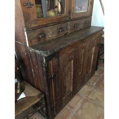 an old wooden cabinet sitting on top of a tiled floor