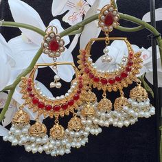 Red and gold desi earrings Luxury Red Chandbalis For Wedding, Luxury Red Temple Jewelry Chandbalis, Luxury Red Chandbalis For Festive Season, Red Chandelier Earrings For Festive Parties, Red Chandelier Earrings For Party And Festive Occasions, Festive Red Chandelier Earrings For Party, Red Bollywood Dangle Jewelry, Bollywood Style Red Dangle Jewelry, Traditional Red Earrings For Party