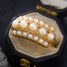 This majestic ring contains two rows of seed pearls encompasing a centered row of larger round pearls. The larger inner pearls and the smaller outer pearls are very well matched. The ring is crafted in buttery 18k yellow gold and is currently a size 6.5. Vintage Pearl And **** Ring, Luxury Baroque Pearl Ring For Anniversary, Luxury Timeless Open Pearl Ring, Luxury Heirloom Pearl Ring, Luxury Elegant Hallmarked Pearl Ring, Luxury Timeless Yellow Gold Pearl Ring, Luxury Yellow Gold Pearl Ring With Brilliant Cut, Pearl Ring Design, Seed Pearl Ring