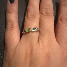 a woman's hand with a ring on it and two stones in the middle